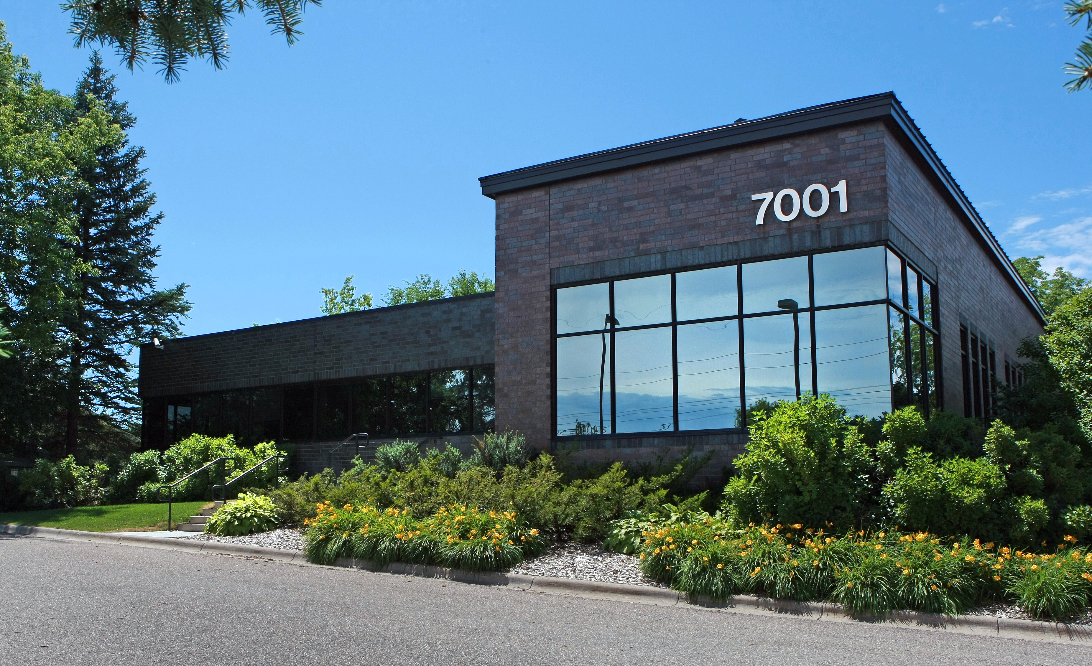 A view of the entrance with frosted doors and a drop-down cloud ceiling