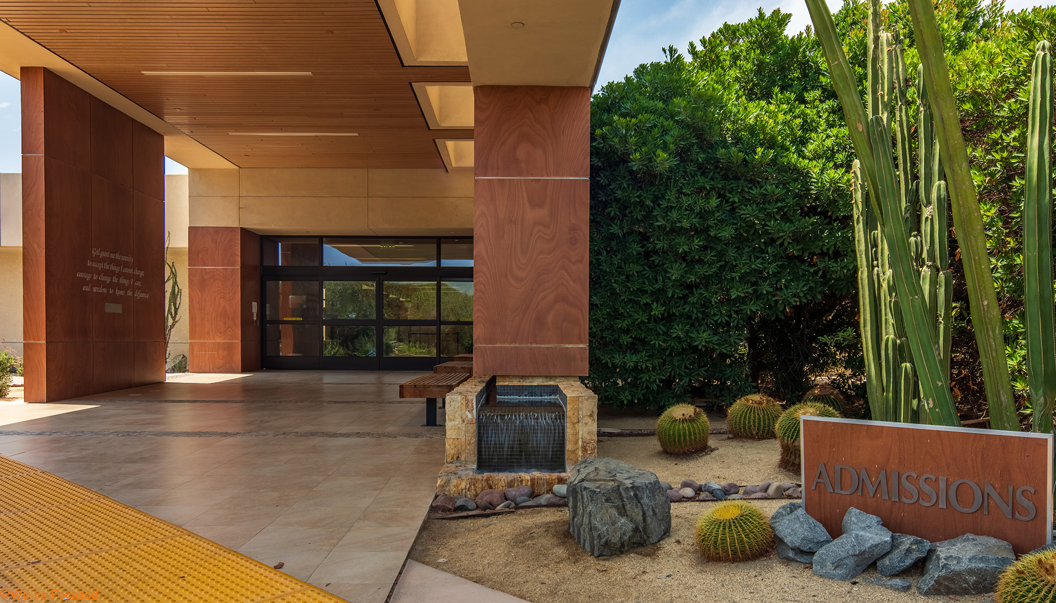 The entrance of the admissions building surrounded by desert plants