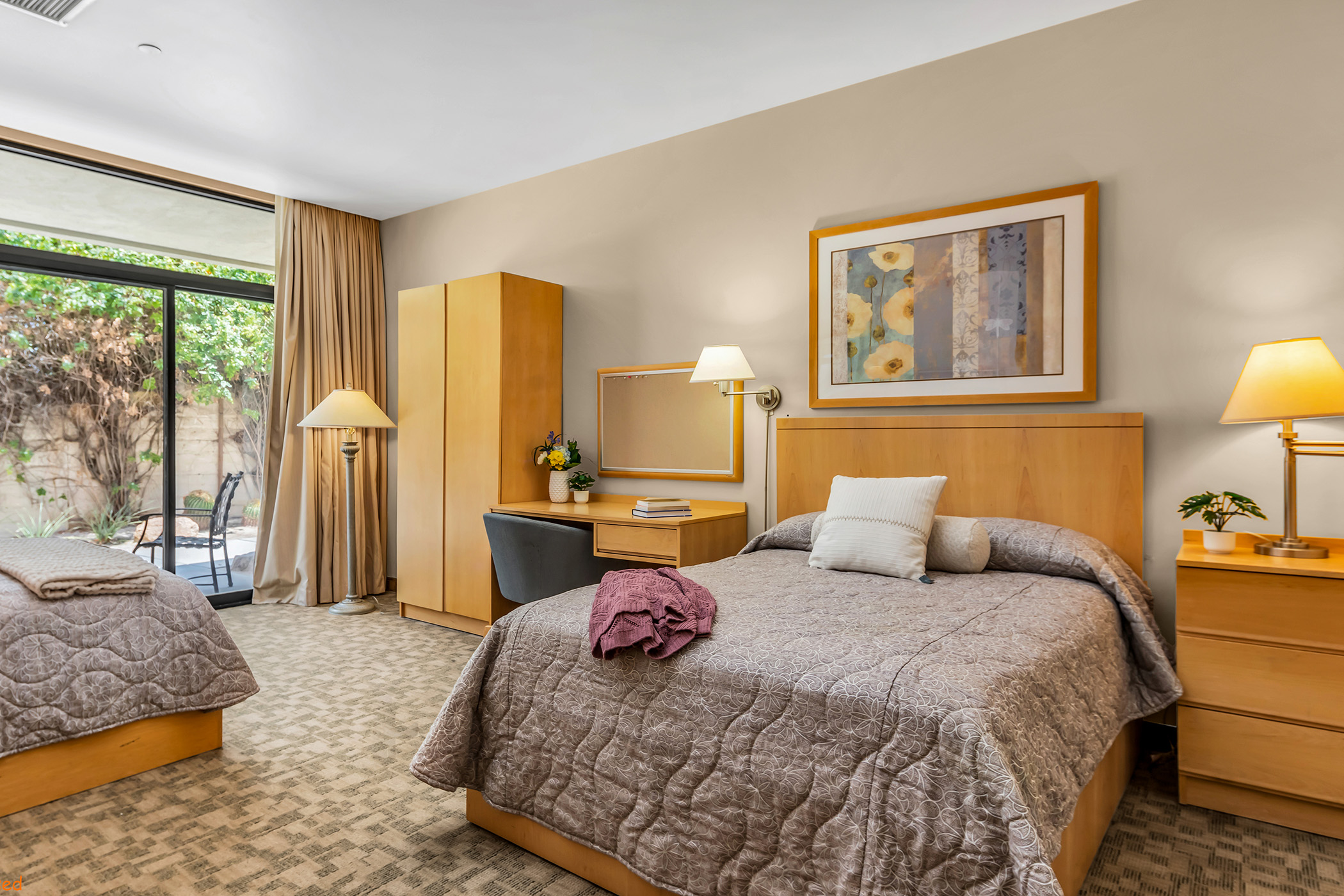 Inside a shared room with two comfortable beds and dressers