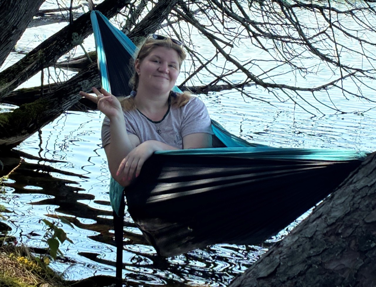 Alumni in hammock along the water
