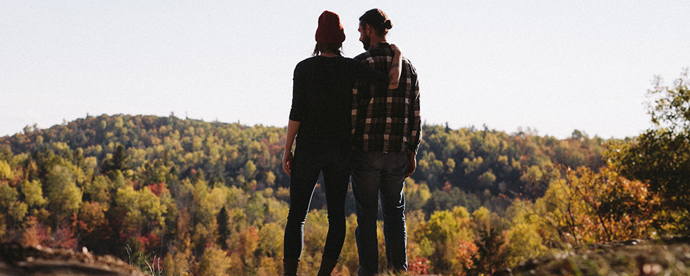Couple looking at a forest view, facing away from the camera